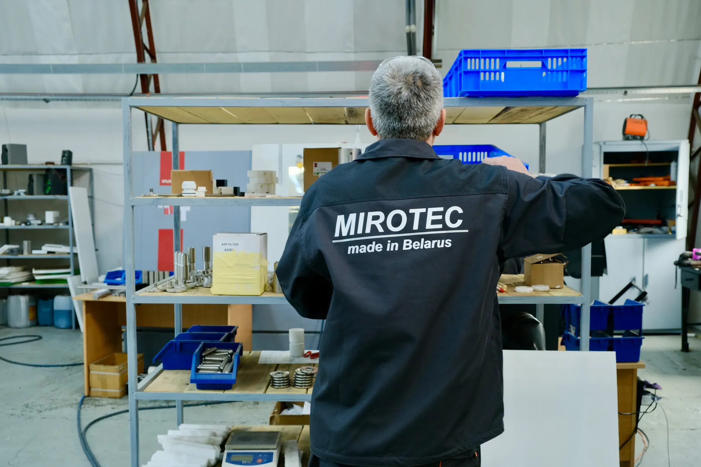 Сотрудник MIROTEC у стеллажа с узлами и комплектующими
